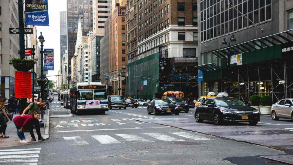 NYC bus at a Manhattan stop with passengers boarding in 2024